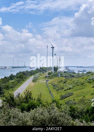 Blick auf das kleine Grundstück mit Straßen- und Windturbinen, das den Kanal Nieuwe Waterweg in der Nähe des Rotterdamer Hafen teilt Stockfoto