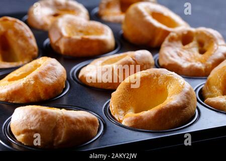 Nahaufnahme der klassischen Yorkshire Puddings im Backblech auf einem Betontisch, englische Küche, Blick von oben, Makro Stockfoto