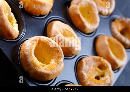 Nahaufnahme der klassischen Yorkshire Puddings in einem Backblech auf einem Betontisch, englische Küche, Blick von oben, Makro Stockfoto