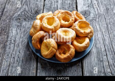 Hausgemachte Yorkshire Puddings auf einer Platte auf einem rustikalen Holztisch, englische Küche, Blick von oben Stockfoto