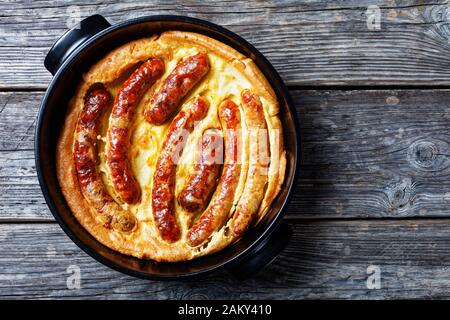 Kröte im Loch, Wurst Toad, traditionelles englisches Gericht, bestehend aus Würstchen in Yorkshire Pudding Batter, horizontale Ansicht von oben, flach Stockfoto