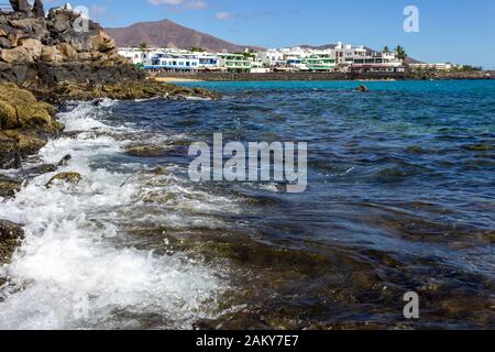 Lavafelsen an der Küste von Playa Blanca auf der Kanareninsel Lanzarote, Spanien. Der Himmel ist blau. Stockfoto