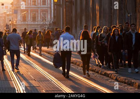 Ukrainische Pendler Spaziergang entlang der Straßenbahn-Linien der alten Stadt in der Dämmerung in Lemberg, Ukraine. Stockfoto