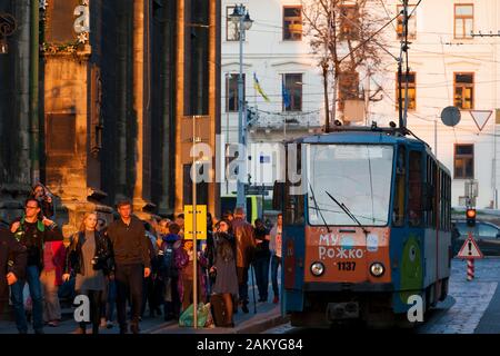 Ukrainische Pendler Spaziergang entlang der Straßenbahn-Linien der alten Stadt in der Dämmerung in Lemberg, Ukraine. Stockfoto