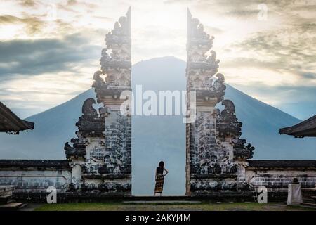 Reisende, die vor den alten Toren des Pura Luhur Lempuyang-Tempels in Bali, Indonesien, stehen. Stockfoto