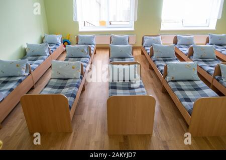 Viele kleine Betten mit frischer Bettwäsche in der Kindertagesstätte Vorschule leere Schlafzimmer Innenraum für komfortable Mittagsschlaf der Kinder. Stockfoto