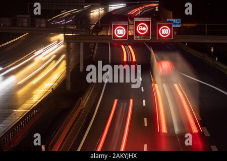 Verkehrssteuerung mit Geschwindigkeitsanzeige bei Nacht, Lichtstreifen von Autos Stockfoto