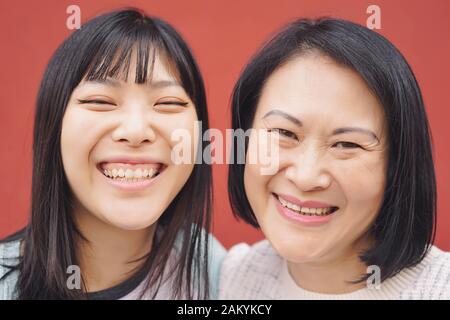 Glückliche asiatische Mutter und Tochter, die Spaß im Freien haben - Portrait chinesische Familienmitglieder verbringen Zeit zusammen draußen Stockfoto