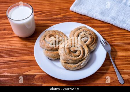 Inländische hausgemachten Gebäck mit Spinat und Käse auf eine Serviette mit einem Glas Joghurt gerollt Stockfoto