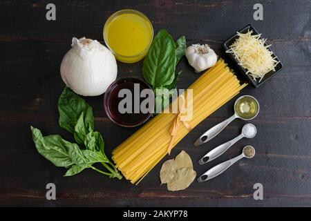 Zutaten für Rotweinpasta: Ungekochte Lingine, Basilikumsprigs und andere Zutaten, die zur Herstellung von Pasta in Rotweinsauce verwendet werden Stockfoto