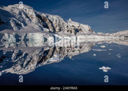 Eis, Gletscher, Berge der Paradise Bay spiegelten sich an einem sonnigen Tag in der Antarktis im Ozean wider Stockfoto