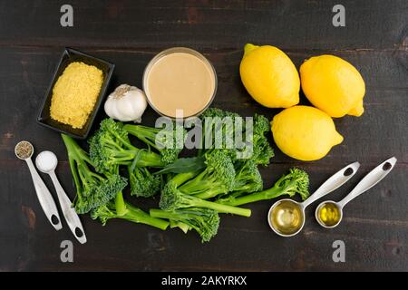 Broccolini mit Lemon Tahini Dressing Zutaten: Rohe Broccolini, Zitronen, Tahini und andere Zutaten Stockfoto