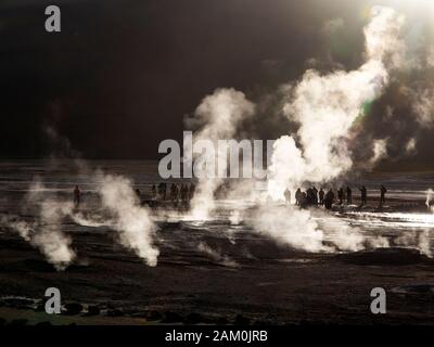 Touristen, die in der berühmten Geiser del Tatio bei Sonnenaufgang, Atacama-wüste, Chile Stockfoto