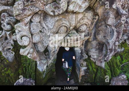 Blick auf Touristen, die in den alten Tempel der Goa Gajah Elephant Cave in Ubud, Bali, Indonesien, eindringen. Stockfoto