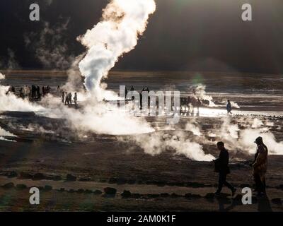 Touristen, die in der berühmten Geiser del Tatio bei Sonnenaufgang, Atacama-wüste, Chile Stockfoto