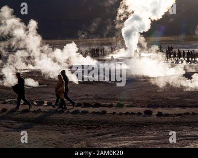 Touristen, die in der berühmten Geiser del Tatio bei Sonnenaufgang, Atacama-wüste, Chile Stockfoto