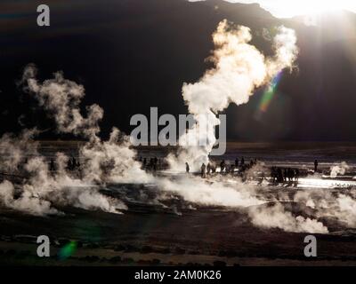 Touristen, die in der berühmten Geiser del Tatio bei Sonnenaufgang, Atacama-wüste, Chile Stockfoto