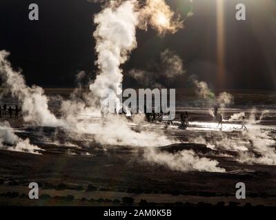 Touristen, die in der berühmten Geiser del Tatio bei Sonnenaufgang, Atacama-wüste, Chile Stockfoto