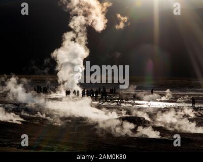 Touristen, die in der berühmten Geiser del Tatio bei Sonnenaufgang, Atacama-wüste, Chile Stockfoto