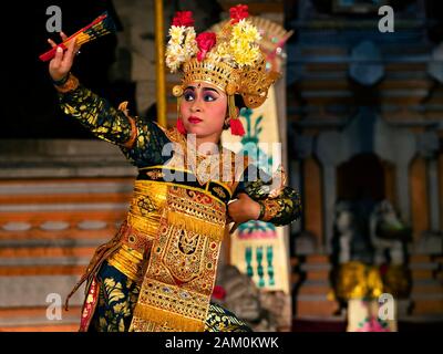 Balinesische Tänzerin, die Legong tanzt und traditionelle Kostüme im Pura Saraswati Tempel in Ubud, Bali, Indonesien trägt. Stockfoto