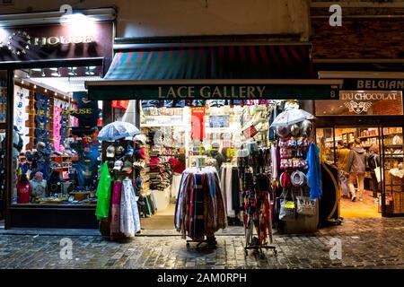 Souvenirläden, Souvenirläden und Schokoladengeschäfte sind spät nachts an einem regnerischen Abend im touristischen Zentrum von Brüssel, Belgien, geöffnet. Stockfoto