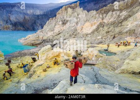 Schwefelminierer, der in den Krater des Kawah Ijen Vulkans in Ostjava, Indonesien, hinunterwandert. Stockfoto