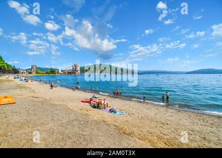 Touristen genießen einen sonnigen Tag am Strand von Independence Point am Lake Coeur d'Alene, in der Bergresortstadt Coeur d'Alene, Idaho. Stockfoto