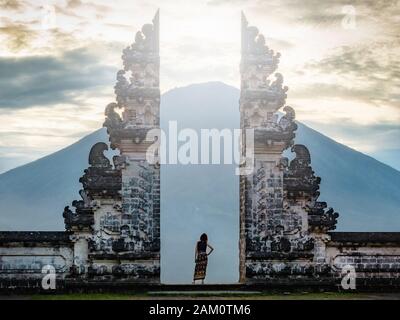 Reisende, die vor den alten Toren des Pura Luhur Lempuyang-Tempels in Bali, Indonesien, stehen. Stockfoto