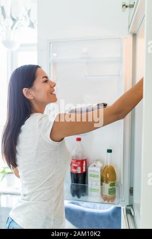 Gesunde Ernährung Konzept. Ernährung. Schöne junge Frau in der Nähe der Kühlschrank mit gesunden Lebensmitteln. Obst und Gemüse im Kühlschrank Stockfoto