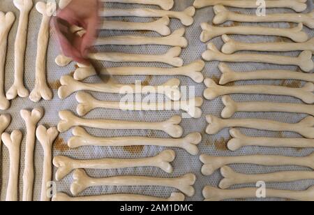 Irsee, Deutschland. 08 Jan, 2020. Gudrun Koneberg, Bäckermeister, Spreads laugen Gebäck in der Bäckerei von ihre Bäckerei in Form von Knochen mit Lauge. Die Bäckerei ist in der Nähe von dem Ort, wo die Gebeine der Primas Udo, die etwa 11,6 Millionen Jahre alt sind, gefunden wurden. (Dpa: "Nachrichten von den Great Ape Udo - Die Primaten sind jetzt verfügbar als Brezeln') Credit: Karl-Josef Hildenbrand/dpa/Alamy leben Nachrichten Stockfoto