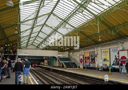 London, Großbritannien - 22. Juni 2019: Passagiere auf dem Bahnsteig für Züge der District Line im historischen edwardianischen Teil der Ealing Broadway Station in West Lond Stockfoto