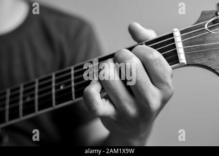 Männer fangen Akkorde lernen Gitarre zu spielen. Closeup-Musiker fangen Gitarrenakkorde. Männliche Musiker halten Akkorde und Strum Gitarre. Stockfoto