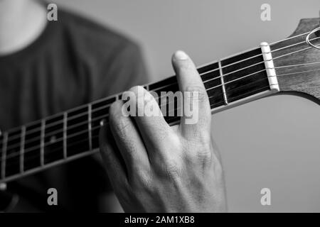 Männer fangen Akkorde lernen Gitarre zu spielen. Closeup-Musiker fangen Gitarrenakkorde. Männliche Musiker halten Akkorde und Strum Gitarre. Stockfoto