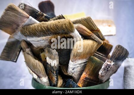 Verschiedene Kunstbürsten unterschiedlicher Stärke und Form für die Arbeit mit Öl- oder Acrylfarbe stehen in der Künstlerwerkstatt, die auf die Entstehung wartet Stockfoto