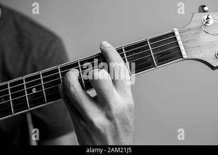 Männer fangen Akkorde lernen Gitarre zu spielen. Closeup-Musiker fangen Gitarrenakkorde. Männliche Musiker halten Akkorde und Strum Gitarre. Stockfoto