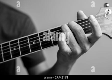 Männer fangen Akkorde lernen Gitarre zu spielen. Closeup-Musiker fangen Gitarrenakkorde. Männliche Musiker halten Akkorde und Strum Gitarre. Stockfoto