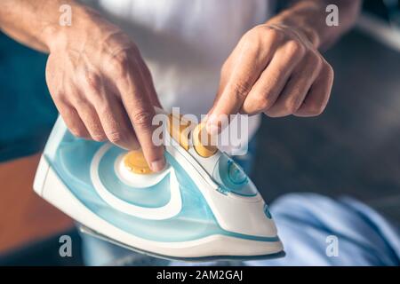 In der Nähe Bild von Mans Hände mit Bügeleisen Stockfoto