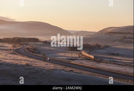 Virgin Trains/Avanti Westküste pendolino Zug, der auf der West Coast Mainline in Cumbria, die von der Autobahn m6 in einer kalten, frostigen Morgen Stockfoto