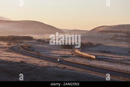 Virgin Trains/Avanti Westküste pendolino Zug, der auf der West Coast Mainline in Cumbria, die von der Autobahn m6 in einer kalten, frostigen Morgen Stockfoto