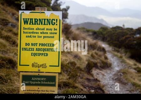 Gehen Sie auf dem Old Ghost Road Trail, Lyell nach Seddonville, Neuseeland. Warnschild an der Ghost Lake Hütte für Reisende in Richtung Norden Stockfoto
