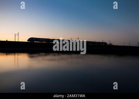 First Transpennine Express CAF Klasse 397 auf der West Coast Mainline bei Sonnenuntergang am ersten Tag im öffentlichen Dienst für diese neue Züge Stockfoto