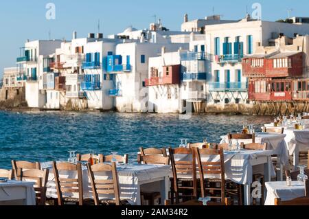 Hellen schönen Nachmittag Blick auf leere Tabellen warten auf den Sonnenuntergang Diners bis entlang des Hafens in der Altstadt von Mykonos, Griechenland Stockfoto
