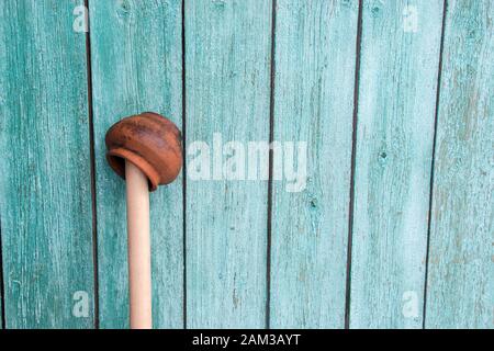 Antike schäbig orange handgefertigte Lehm Topf auf einem Holzstab auf Holz gemalten Hintergrund. Dorf Thema. Vintage Konzept Stockfoto