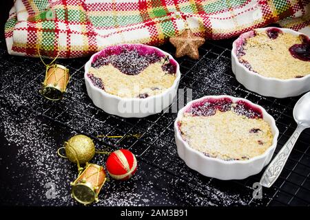 Hausgemachte köstliche Haferbrei zerfällt mit Beeren in portionierten, individuellen Ramekinen. Gesundes Frühstück. Weihnachtskonzept Stockfoto
