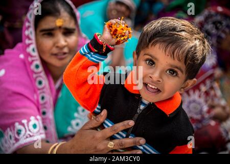 Kinder, die während des Holi-Festivals in einem Dorf in der Nähe von Mathura Blumen werfen. Mathura, Indien Stockfoto