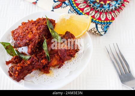 Authentisches indisches Huhn mit Gewürzen, Curryblatt und Kokosnuss - payyoli Hühnerbrate. Berühmter Kerala-Kurs. Kopierbereich. Weißer Hintergrund Stockfoto