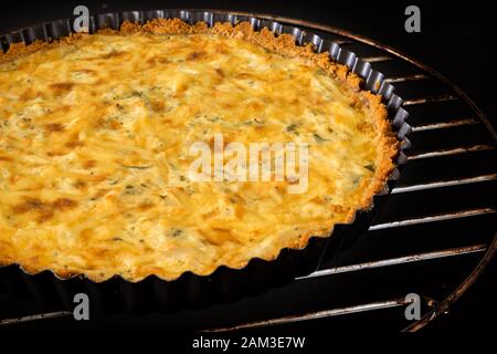 Hausgemachtes Huhn Quiche Käse Grüne Zwiebel Petersilie und Pizza Messer auf schwarzem Hintergrund Stockfoto