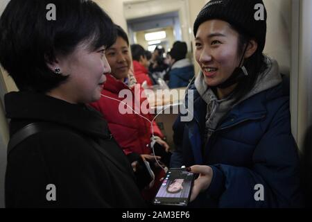 (200111) - LANZHOU, Jan. 11, 2020 (Xinhua) - Studenten Chat auf der Zug Nr. 7505, als sie auf dem Weg nach Hause für Winterurlaub im Nordwesten der chinesischen Provinz Gansu, Jan. 10, 2020. Der Zug Nr. 7505, die reist von Lanzhou, Wuwei, ist ein vier-Schlitten gewöhnlicher Zug. Der Zug, der mehr als ein Dutzend kleine Stationen zwischen Lanzhou und Wuwei, läuft 290 Kilometer in 5 Stunden und 27 Minuten. Der volle Fahrpreis beträgt 18,5 Yuan (etwa 2,7 US-Dollar), mit den niedrigsten Tarif von 1 Yuan. Es läuft seit fast 40 Jahren seit den 1980er Jahren, mit fast 10 Millionen Passagiere. D Stockfoto