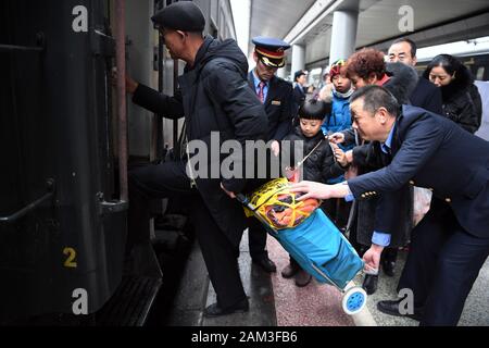 (200111) - LANZHOU, Jan. 11, 2020 (Xinhua) - Mitarbeiter helfen Passagiere auf dem Zug Nr. 7505 an der Lanzhou Bahnhof in Lanzhou, der Hauptstadt der Provinz Gansu im Nordwesten Chinas, Jan. 10, 2020. Der Zug Nr. 7505, die reist von Lanzhou, Wuwei, ist ein vier-Schlitten gewöhnlicher Zug. Der Zug, der mehr als ein Dutzend kleine Stationen zwischen Lanzhou und Wuwei, läuft 290 Kilometer in 5 Stunden und 27 Minuten. Der volle Fahrpreis beträgt 18,5 Yuan (etwa 2,7 US-Dollar), mit den niedrigsten Tarif von 1 Yuan. Es läuft seit fast 40 Jahren seit den 1980er Jahren, mit fast 10 Millionen Stockfoto