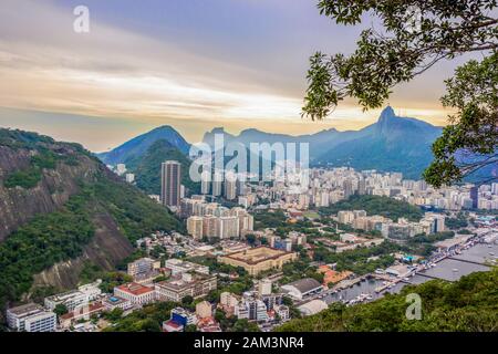 Rio De Janeiro Amazing View, Urca Hill, Sugar Loaf Mountain, Evening Clouds, Sunset. Gebäude, Stadtzentrum, Jesus Erlöser-Statue, Küste Des Ozeans Und Stockfoto